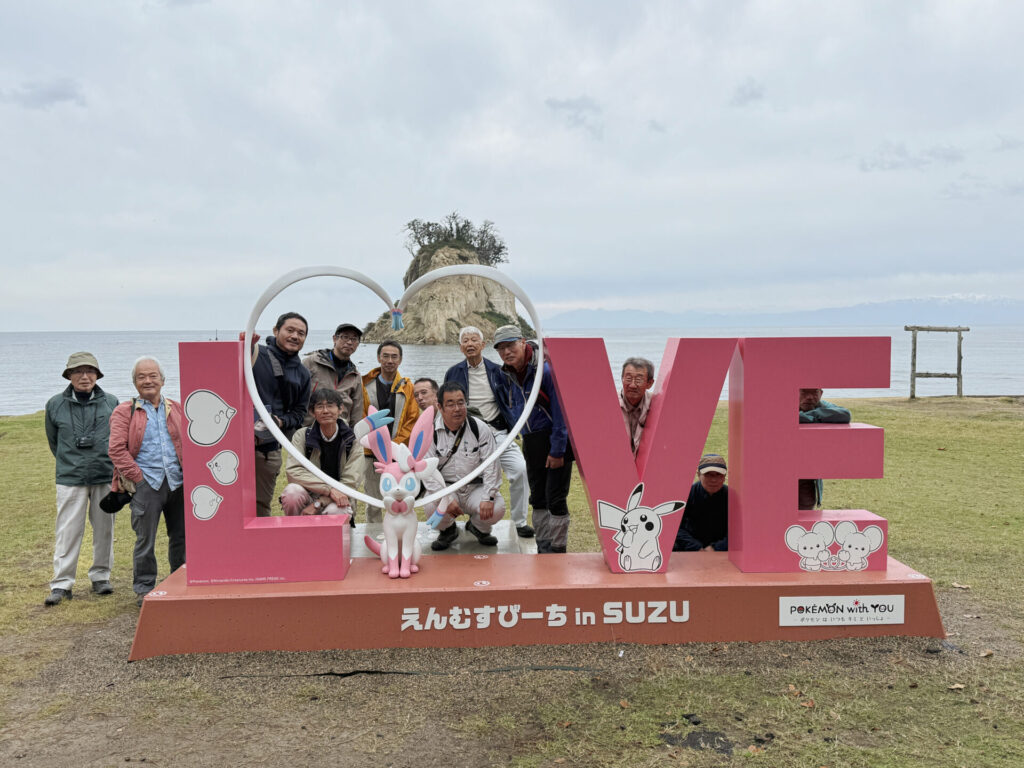 日本応用地質学会中部支部の令和7年現地学会の記念撮影.見附島前のポケモンモニュメントの前で撮影.