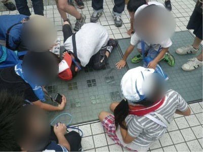 オアシス21周辺で足元の石材を観察する子どもたち