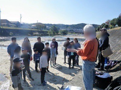 化石発掘の説明を聞く親子