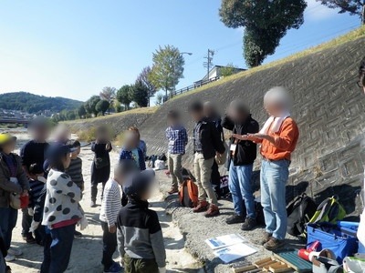 河原で化石発掘の注意点の説明を聞く参加者